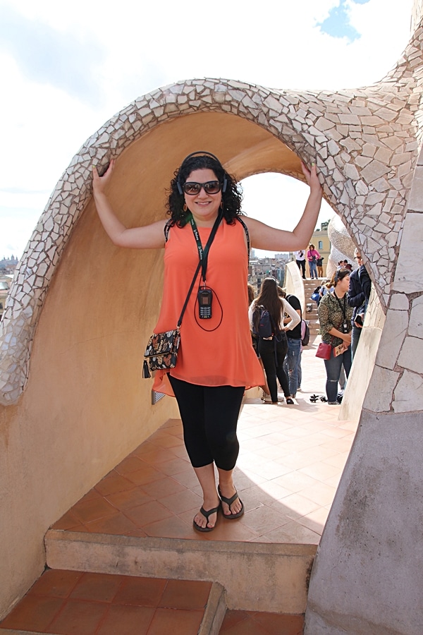 a woman standing under a mosaic archway