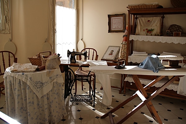 a room with a sewing machine and ironing board