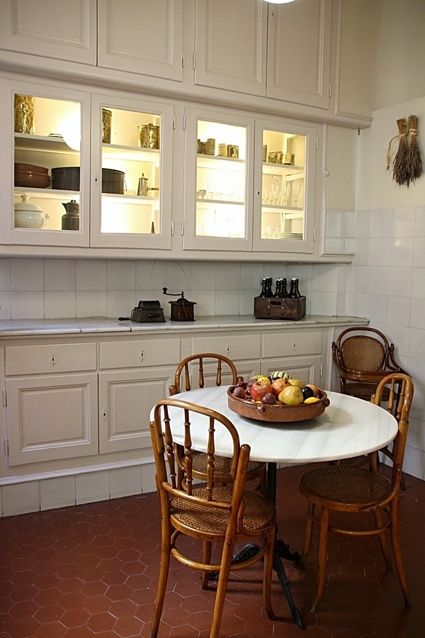 A kitchen with a table and glass covered cabinets