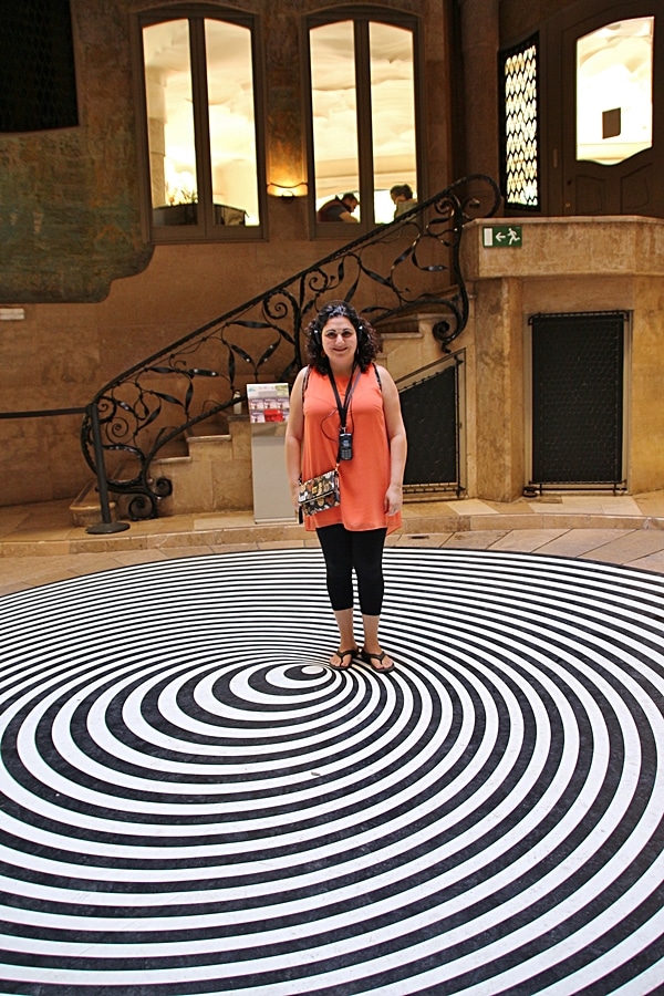 A woman standing on a black and white spiral floor