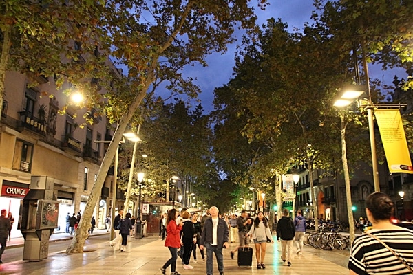 A group of people walking down Las Ramblas in Barcelona at night