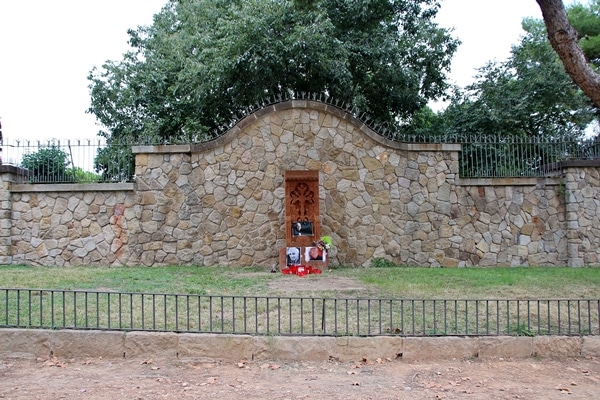 a stone wall in front of a bunch of trees