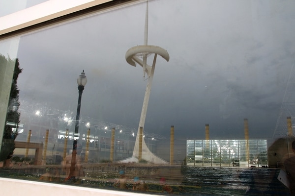 reflection of a tall white communications tower in a window