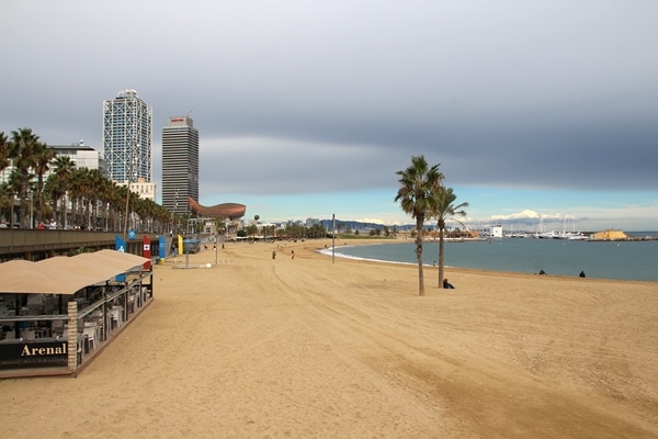 A sandy beach with buildings in the distance