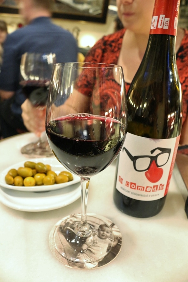 A close up of a glass and bottle of wine on a table