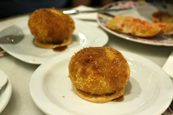 2 fried potato balls on white plates