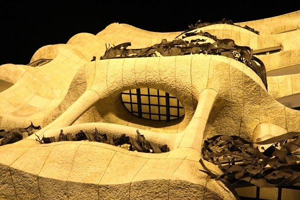 view looking up at curvy, ornately carved balconies at night