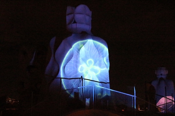 illumination of a jelly fish on the side of a stone chimney at night