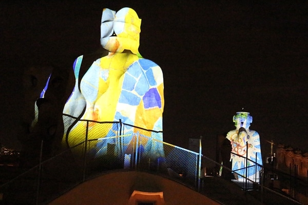 stone chimneys illuminated with colorful images at night