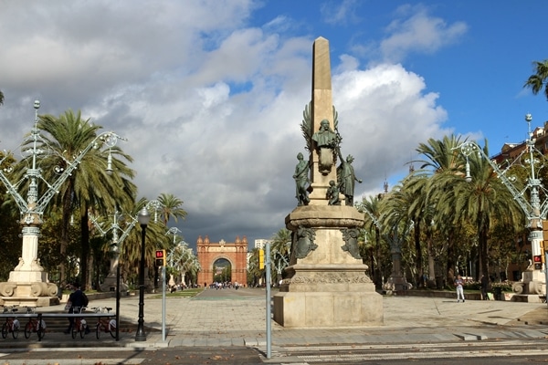 a monument in an open space lined with palm trees