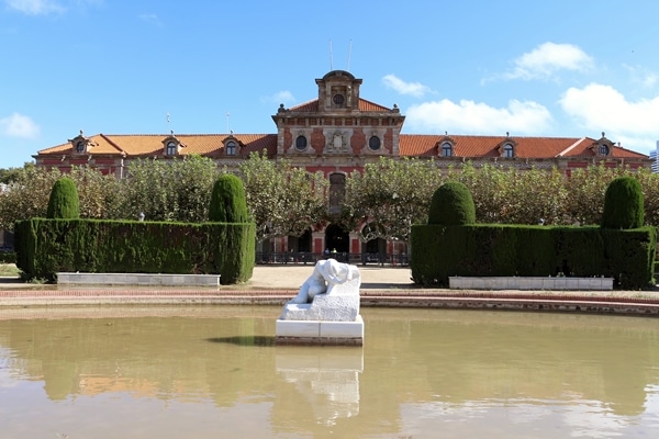 a sculpture in a body of water with gardens beyond