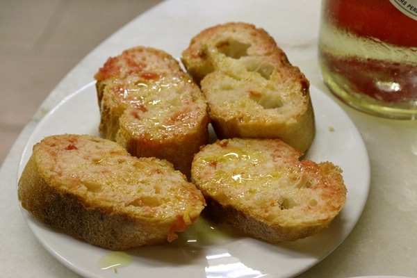 a plate of toasted bread rubbed with tomato