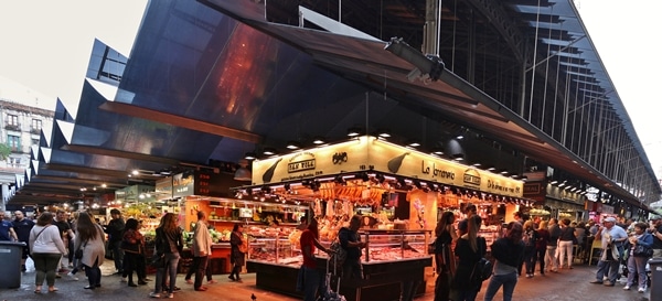 wide view of interior of La Boqueria food market lined with stalls