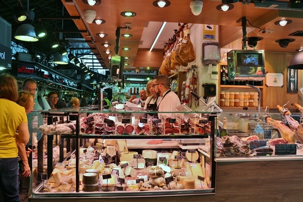 a meat and cheese stall inside a farmer\'s market