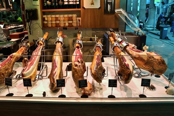 several legs of Spanish ham on display for sale