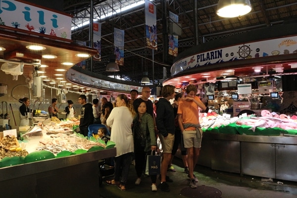 A group of people standing in a food market