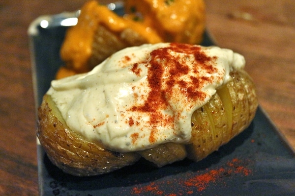 A close up of a potato topped with a white sauce