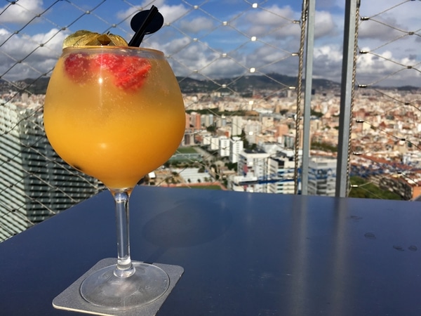 A glass of white sangria overlooking Barcelona from a rooftop