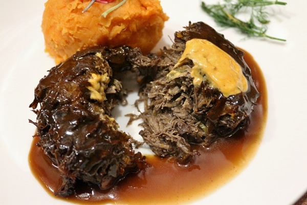 closeup of braised beef cheeks on a white plate