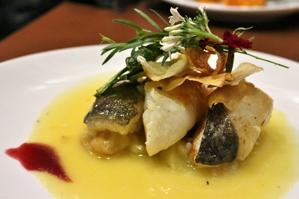 closeup of a plate of fish with a yellow sauce