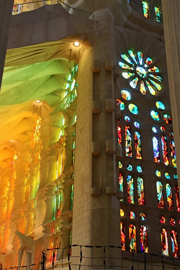 a kaleidoscope of colorful light streaming through stained glass windows inside Sagrada Familia 