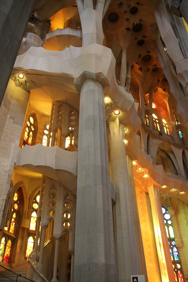 stone staircase inside Sagrada Familia with bright yellow light coming through the windows
