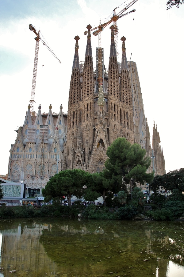 a wide view of Sagrada Familia from across a pond