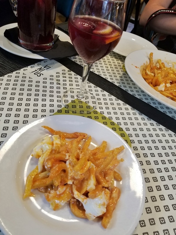 a plate of food and a glass of sangria on a table