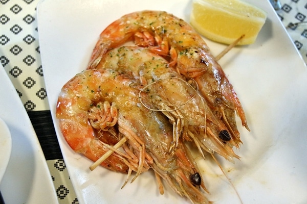 closeup of grilled langoustines on a white plate