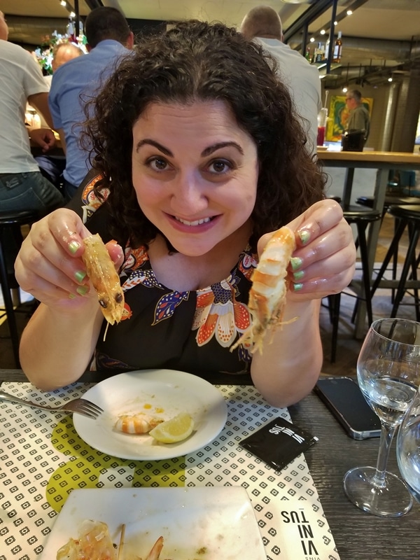 a woman holding up 2 langoustines