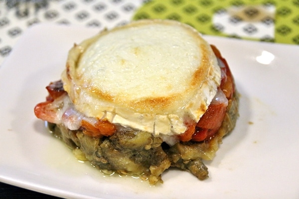 roasted eggplant and peppers topped with goat cheese on a plate