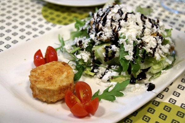 a plate of salad topped with cheese