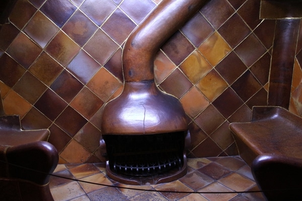 an unusual looking fireplace surrounded by brown tiles