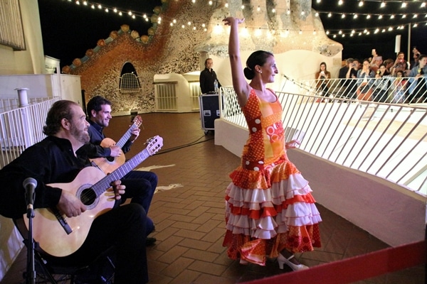 2 guitarists and a female flamenco dancer in an orange dress