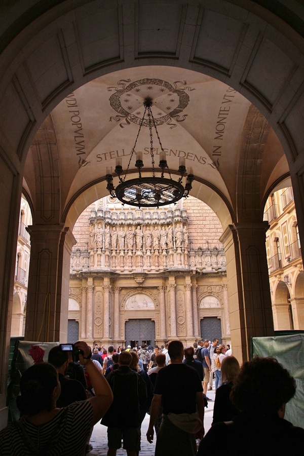 A group of people standing under an archway in front of a building