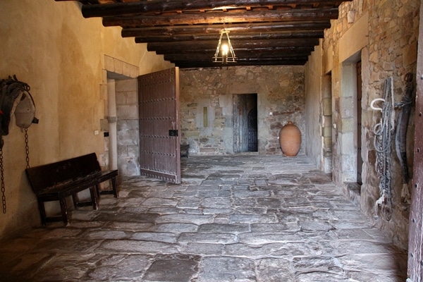 A room with a stone floor and wooden beam ceiling