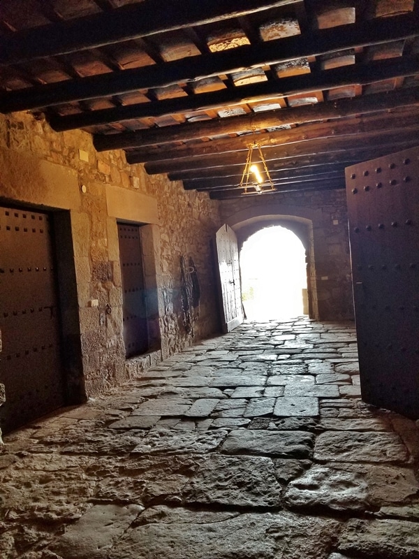 a room with a stone floor and several old-looking doors