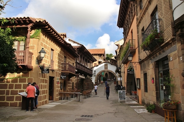 A person walking down a street next to a brick building