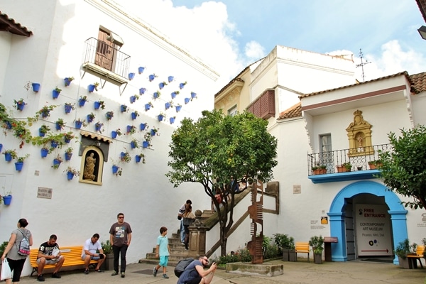 a whitewashed building with blue pots on the wall