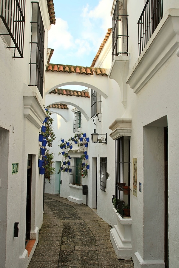 a narrow open-air walkway with whitewashed walls