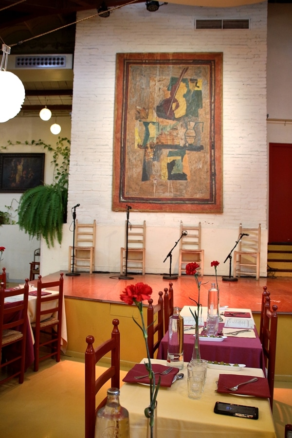 a restaurant dining room with a stage to one side