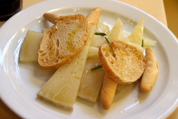 sliced cheese with crispy bread on a white plate