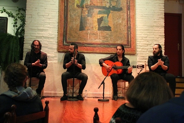 A group of musical performers sitting on a stage