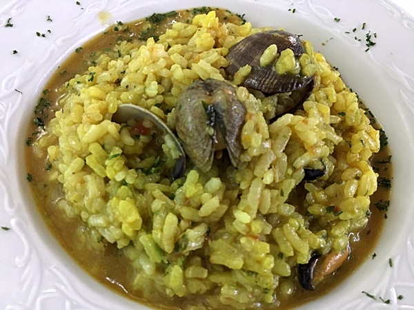 A bowl of rice with clams on a plate