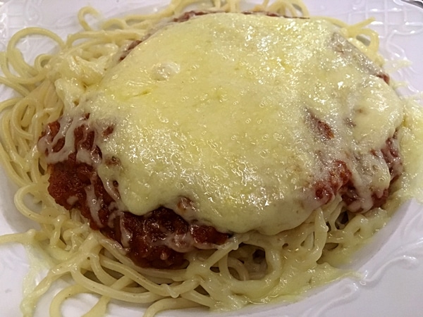 A close up of a plate of pasta with sauce and cheese