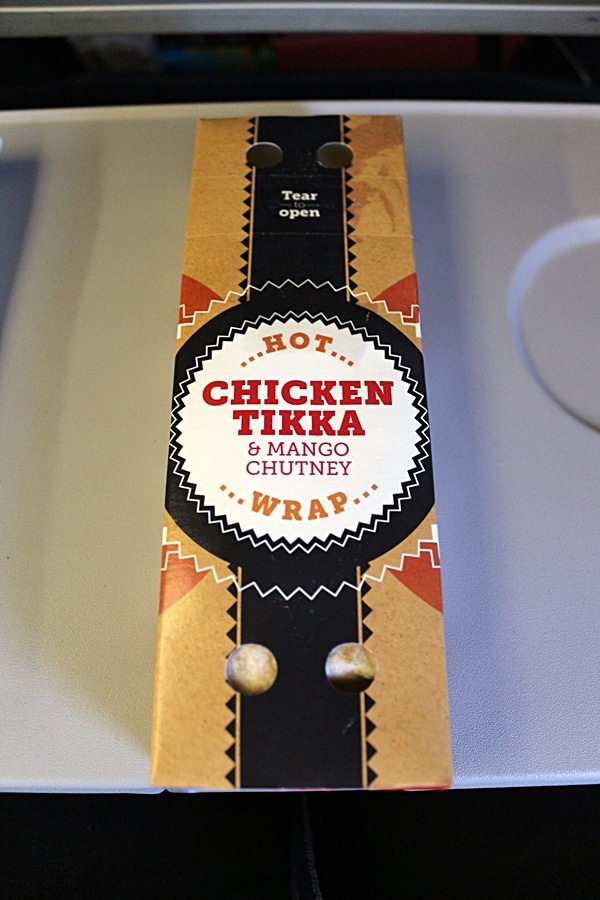 package for a Chicken Tikka Wrap on an airplane tray table