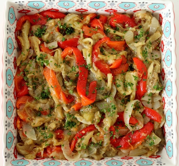 Roasted red peppers, eggplants, and onions with parsley, served in a decorative square dish