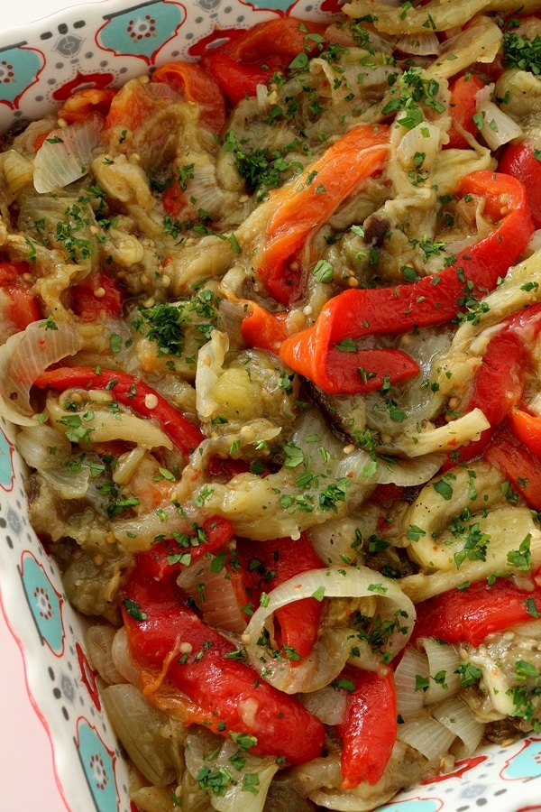 Roasted red peppers, eggplants, and onions with parsley, served in a decorative square dish