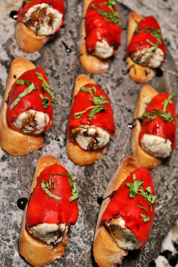 overhead view of a platter of goat cheese stuffed piquillo pepper bruschetta