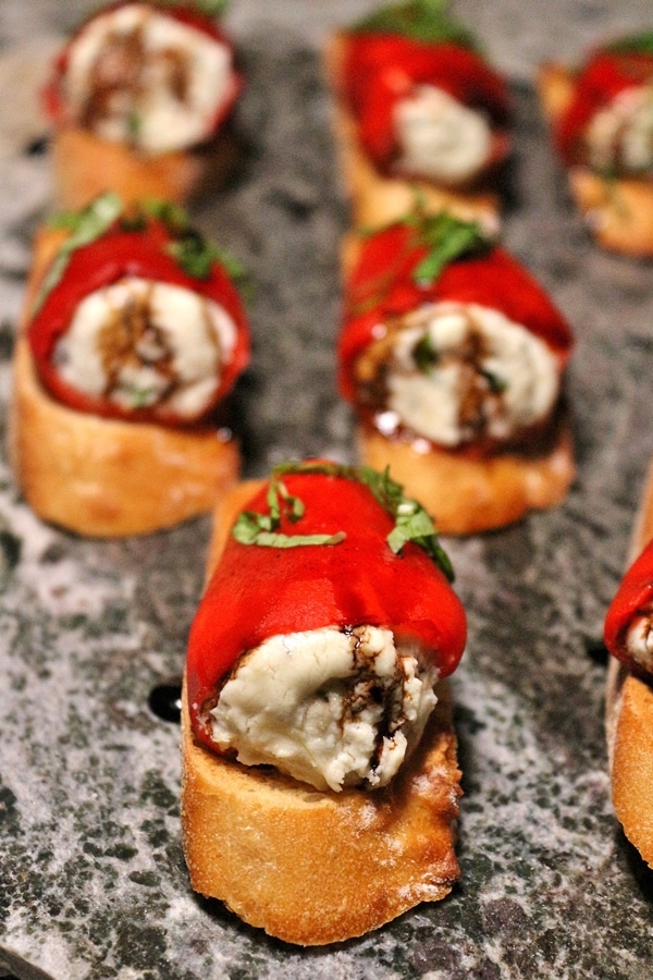 closeup of stuffed piquillo peppers with goat cheese on sliced baguettes